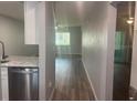 Hallway view towards a room with a window, stainless steel dishwasher and sink visible to the left at 6520 Thicket Trl, New Port Richey, FL 34653