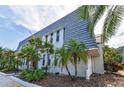 Charming exterior elevation with a well-manicured lawn and tropical plants around the property at 704 Lyndhurst St # 624, Dunedin, FL 34698