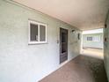 Exterior walkway featuring door, window, and light green textured wall at 801 83Rd N Ave # 107, St Petersburg, FL 33702