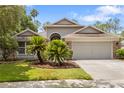 Charming single Gathering home with a lush front lawn and a two car garage on a sunny day at 9047 Quail Creek Dr, Tampa, FL 33647