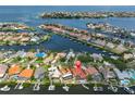 Gorgeous aerial view of a waterfront home featuring lush landscaping, a swimming pool and boat docks at 920 Symphony Isles Blvd, Apollo Beach, FL 33572