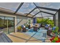 Relaxing screened-in patio with stylish outdoor seating and a view of the lush backyard at 9423 Lemon Drop Loop, Sun City Center, FL 33573