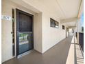 Condo entrance with textured wall, black trimmed storm door, and view of the exterior at 9450 Harbor Greens Way # 207, Seminole, FL 33776
