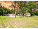 Sprawling property with mature trees, a well-manicured lawn, and a charming home featuring an attached garage at 1025 Reading Rd, Lutz, FL 33558