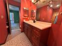 Bathroom with a vanity sink, large mirrors, and colorful walls at 11394 Collingswood St, Spring Hill, FL 34608