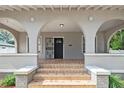 Arched covered porch with decorative columns and tile steps leading to the front door at 1203 E New Orleans Ave, Tampa, FL 33603