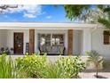 Cozy front porch with comfortable seating, decorative plants, and stylish wooden support beams at 125 Live Oak Ln, Largo, FL 33770