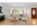 Bright living room featuring a large window, hardwood floors, and a comfortable sofa with stylish decor at 125 Live Oak Ln, Largo, FL 33770