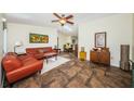 Cozy living room boasts a ceiling fan, skylight, comfortable furniture and access to the dining area at 12873 Cumberland Dr, Largo, FL 33773