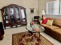 Comfortable living area with a decorative rug, brown sofa, and ornate china cabinet for storage at 14530 Apache Ave, Largo, FL 33774