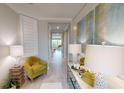 Bright hallway with neutral colors and decor, leading to multiple rooms and features a large decorative art piece at 15021 Oxford Grey Dr, Lakewood Ranch, FL 34211