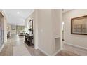 Hallway featuring tile floors, a view of the Gathering room and dining area, and neutral paint at 15127 Oxford Grey Dr, Bradenton, FL 34211