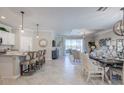 Open-concept living and dining area with tile flooring, neutral decor, and a view of the water at 15135 Oxford Grey Dr, Bradenton, FL 34211