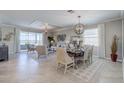 Living and dining area with elegant lighting fixtures, neutral decor, and large windows at 15135 Oxford Grey Dr, Bradenton, FL 34211
