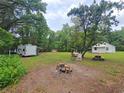 Expansive backyard with a fire pit, camper, and rustic seating, perfect for outdoor gatherings at 18452 Fort Dade Ave, Brooksville, FL 34601