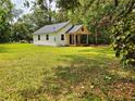 Quaint cottage-style home with white siding and a cozy front porch nestled on a spacious lawn at 18452 Fort Dade Ave, Brooksville, FL 34601