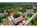 Aerial view of a home with a pool, surrounded by mature trees and lush greenery at 1902 Rebecca Rd, Lutz, FL 33548