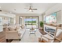Bright living room with a fireplace, ceiling fan, hardwood floors, and sliding doors to the patio at 19191 Pease Pl, Lutz, FL 33558