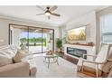 Cozy living room features hardwood floors, a ceiling fan, fireplace, and sliding glass doors with a scenic view at 19191 Pease Pl, Lutz, FL 33558