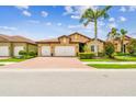 Charming home featuring a brick driveway, manicured landscaping, and a spacious three-car garage at 222 Toscavilla Blvd, Nokomis, FL 34275