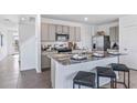 Open kitchen featuring granite countertops, stainless appliances, and a stylish breakfast bar with stool seating at 2661 Birney Run, Zephyrhills, FL 33541