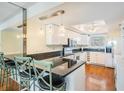 Modern kitchen with white cabinets, granite countertops, and a breakfast bar with seating at 2700 Bayshore Blvd # 497, Dunedin, FL 34698