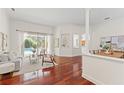 Elegant living room with open layout, gleaming hardwood floors, and view of outdoor pool at 2901 Laurel Meadow Ct, Plant City, FL 33566