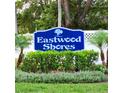 Eastwood Shores community sign surrounded by lush landscaping and a white picket fence at 2935 Lichen Ln # D, Clearwater, FL 33760