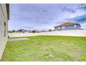 Large, fenced backyard with ample green space and a concrete patio area at 3012 Magnolia Meadows Dr, Plant City, FL 33567