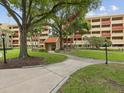 Exterior view of a multi-story building featuring well-maintained landscaping and a welcoming entrance at 3062 Eastland Blvd # 405, Clearwater, FL 33761