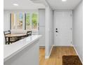 Bright entryway featuring wood floors, a modern front door, and a view of the dining area and windows at 3062 Eastland Blvd # 405, Clearwater, FL 33761