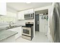 Well-lit kitchen with stainless steel appliances, white cabinets, and granite countertops at 3217 Saddlebrook Ave, Tampa, FL 33618