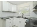 Bright kitchen featuring white cabinets, granite countertops, and stainless steel sink at 3217 Saddlebrook Ave, Tampa, FL 33618