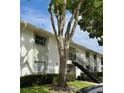 Building exterior featuring stairs leading to units, with a mature tree adding shade at 3802 N Oak Dr # W22, Tampa, FL 33611
