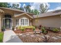 Inviting front entry with decorative planters, garden beds, and a stone bench at 3821 Turkey Oak Dr, Valrico, FL 33596