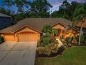 An elevated front-facing view of the home, showing its landscaping, driveway, and well-maintained roof at 4133 Auston Way, Palm Harbor, FL 34685
