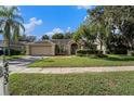 Charming single-story home featuring a manicured lawn, mature landscaping, and a two-car garage at 4303 Kipling Ave, Plant City, FL 33566
