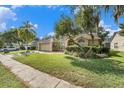 Landscaped front yard of single-story home with mature trees and neatly kept lawn and sidewalk at 4303 Kipling Ave, Plant City, FL 33566