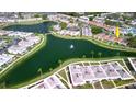 Aerial view of a waterfront community with lush landscaping, a lake, and multiple residential buildings at 4324 Tahitian Gardens Cir # J, Holiday, FL 34691