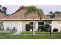 Charming single-story home with a well-manicured lawn, palm tree, and cozy front porch seating at 4324 Tahitian Gardens Cir # J, Holiday, FL 34691
