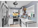 Well-lit kitchen with stainless steel appliances, bright white cabinets, and farmhouse style sink at 4425 W Bay Ave, Tampa, FL 33616