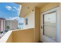 Balcony view of the coastline, ocean, and neighboring building with a secure doorway at 4750 Cove Cir # 1001, St Petersburg, FL 33708
