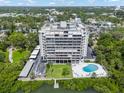 Aerial view of the building and pool and waterfront location surrounded by mature trees at 500 N Osceola Ave # 811, Clearwater, FL 33755