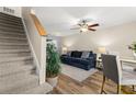 Inviting living area with a plush sofa, ceiling fan, staircase, and stylish decor on wood-look floors at 5100 Burchette Rd # 2702, Tampa, FL 33647