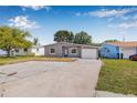 Inviting one-story home with a spacious driveway, manicured lawn, and attached garage, set against a blue sky at 5326 22Nd N Ave, St Petersburg, FL 33710