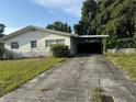 Single-story home with long driveway, covered carport, and well-kept landscaping at 5600 9Th N Ave, St Petersburg, FL 33710