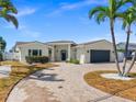 Stylish single Gathering house with a two-car garage, modern driveway, and well-maintained landscaping at 600 115Th Ave, Treasure Island, FL 33706