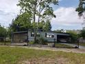 This single-story home features an attached carport and is surrounded by a chain-link fence at 6095 108Th N Ave, Pinellas Park, FL 33782