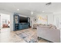Spacious living room with a fan, TV, shelving, and view into an adjacent room at 629 Fort Duquesna Dr, Sun City Center, FL 33573
