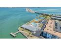 Aerial view showing tennis courts, pool, clubhouse, and waterfront access with a fishing pier at 7 Elgin Pl # 202, Dunedin, FL 34698